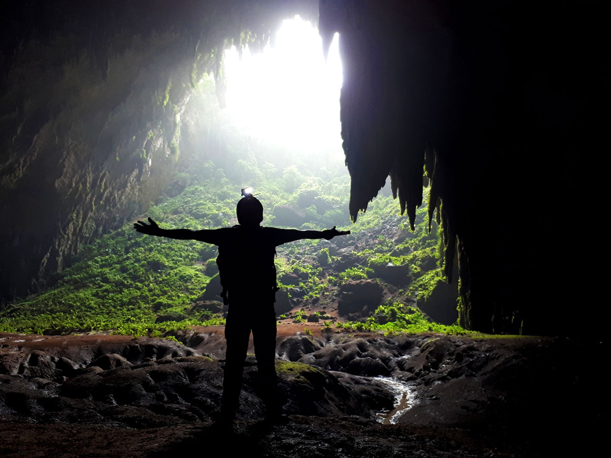 Silhouette of Ian Limpangog at the mouth of Langun Cave